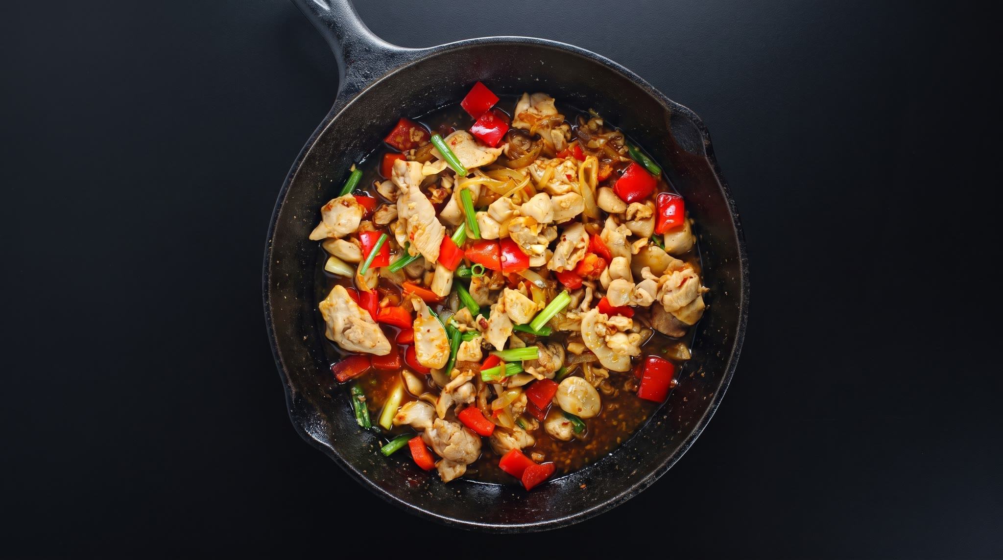 Vietnamese-inspired lemongrass chicken stir-fry with red peppers, onion, and green onions in a cast-iron skillet
